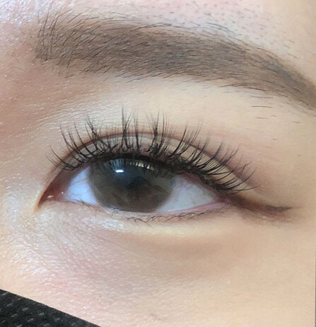 Eyelash extensions with brown eye shadow, eyeliner, and mascara.