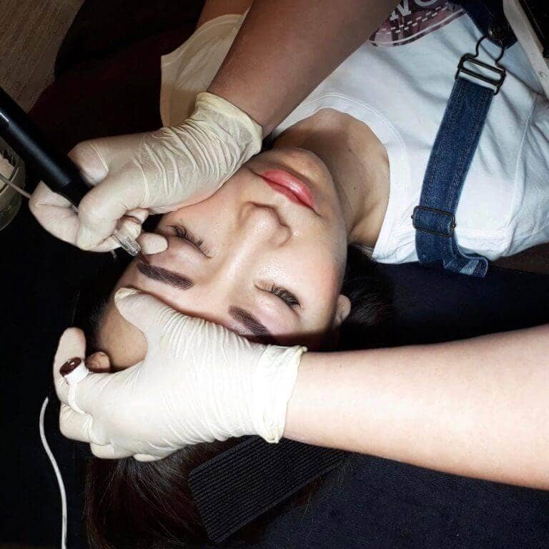 Person receiving medical makeover with black hair and cosmetics.
